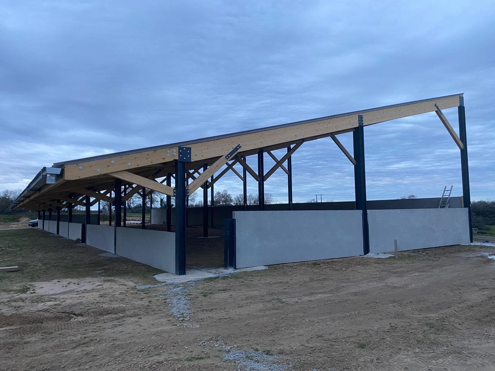 Hangar agricole ouvert à ossature bois-métal, poteaux acier et charpente bois