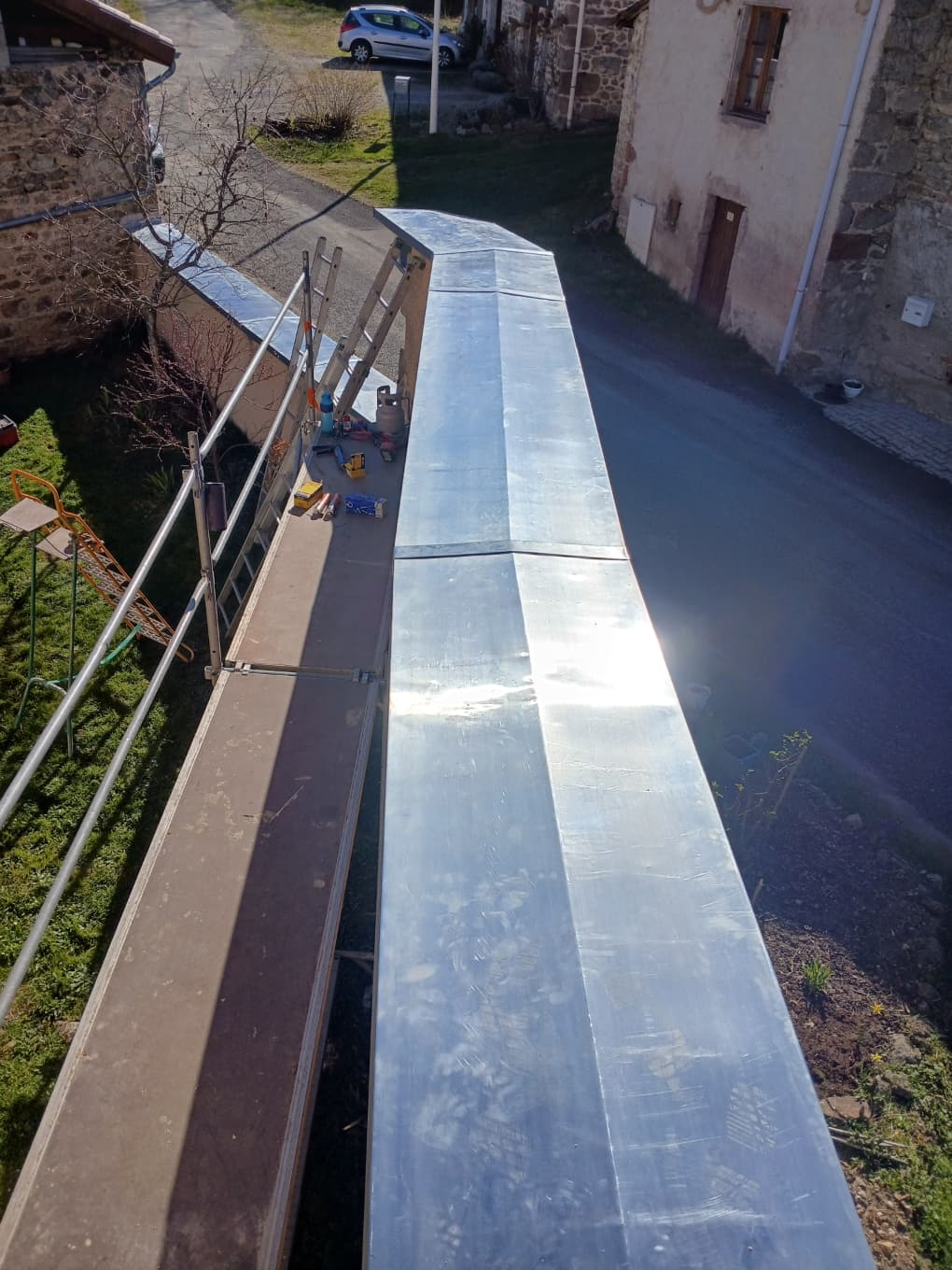 Pose d'une couvertine en zinc sur un mur, échafaudage et outillage, Le Buisson