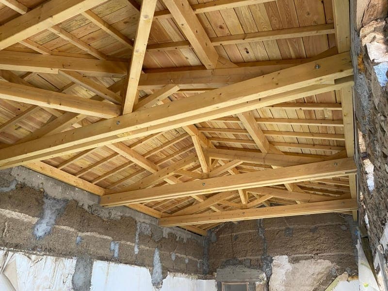 Charpente traditionnelle rénovée, fermes et assemblages bois sur une maison en pierre à Champoly
