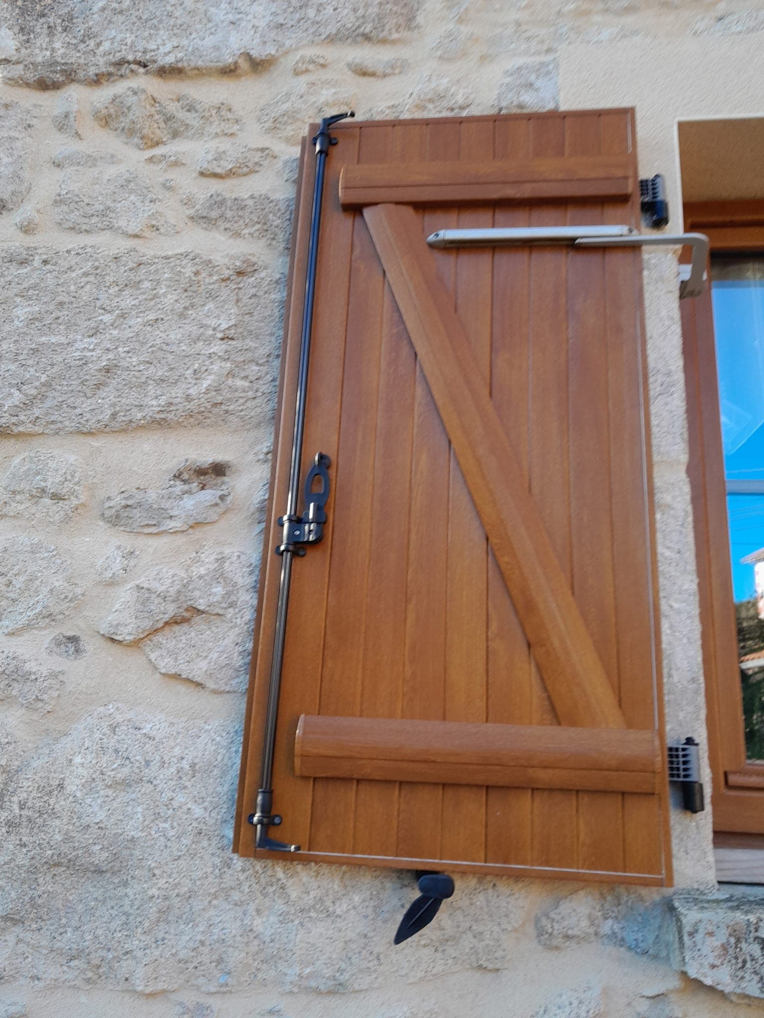 Volet battant bois sur mur en pierre